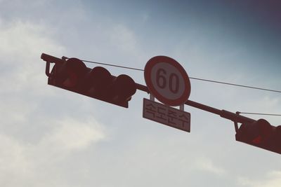 Low angle view of road sign against sky