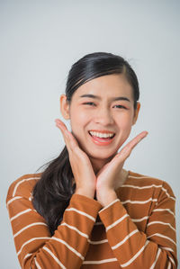 Portrait of a smiling young woman over white background