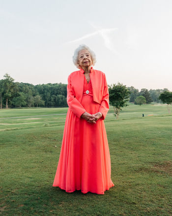 FULL LENGTH OF WOMAN STANDING ON FIELD AGAINST SKY