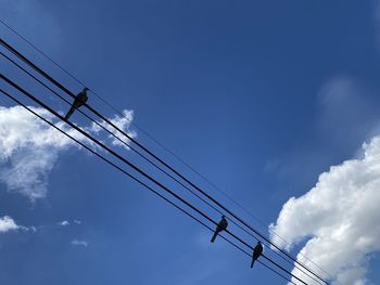 Low angle view of cables against blue sky