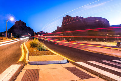 Light trails on road against sky at night