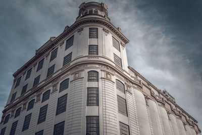 Low angle view of building against cloudy sky