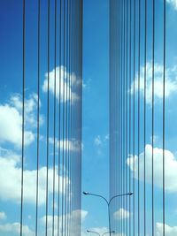 Low angle view of railing against cloudy blue sky