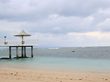 Lifeguard hut on beach against sky