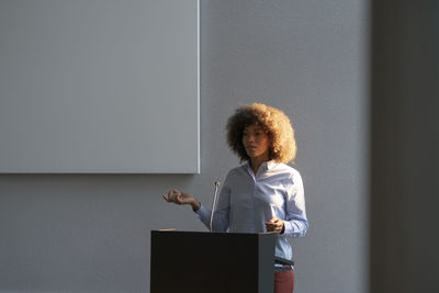 Businesswoman giving speech at work place