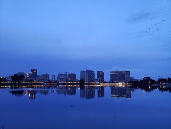 Reflection of illuminated buildings in city at dusk