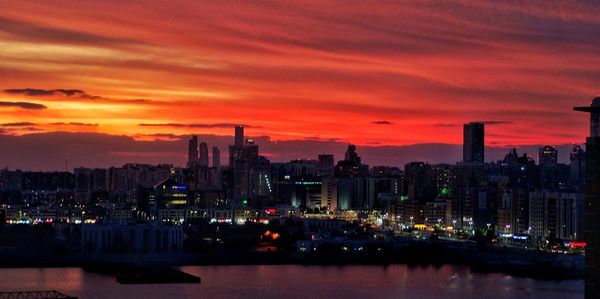 Illuminated buildings against sky during sunset