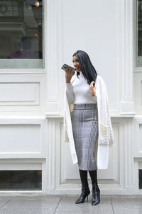 Full length of woman standing against door