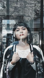 Close-up of young woman standing against wall