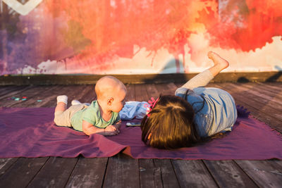 Siblings lying down on wood