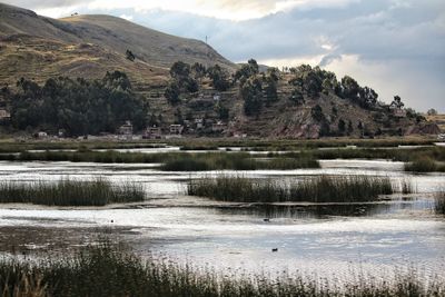 Scenic view of lake by mountain against sky