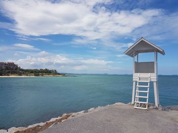 Lifeguard hut on beach against sky