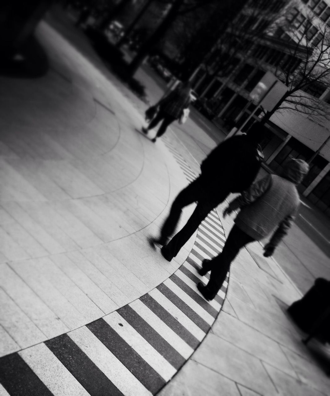 lifestyles, leisure activity, men, full length, walking, high angle view, person, city life, shadow, on the move, street, togetherness, motion, city, sunlight, rear view, blurred motion