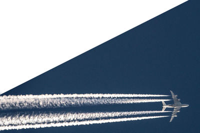 Tilt image of airplane flying against sky
