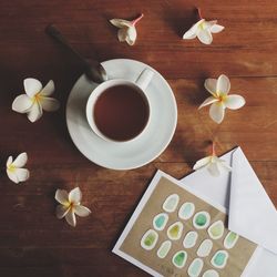 Tea with flowers and envelope on table