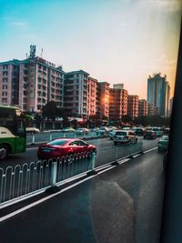 Vehicles on road in city against sky