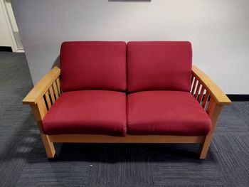 Empty red sofa against wall at home