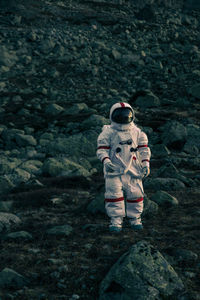 Astronaut standing on land against mountain