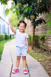 Full length of cute girl standing on footpath