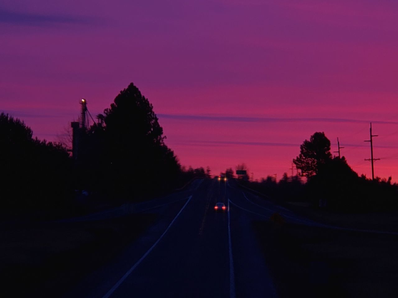 ROAD AMIDST SILHOUETTE TREES AGAINST SKY DURING SUNSET