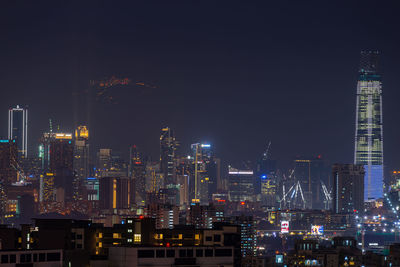 Illuminated buildings in city against sky at night