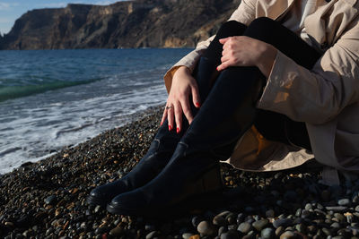 Low section of woman sitting at beach