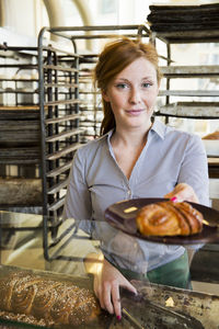 Young woman with cinnamon bun on plate, stockholm, sweden
