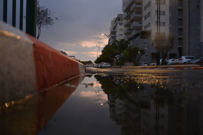 Reflection of buildings in city at sunset