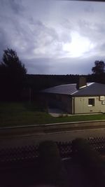 Road by buildings against sky