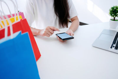 Midsection of woman using laptop on table