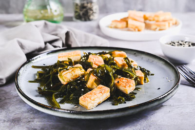 Vegetarian fried tofu and seaweed salad on a plate on the table