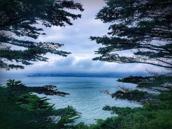 Scenic view of calm sea against cloudy sky