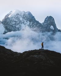 Man on rock in mountains against sky