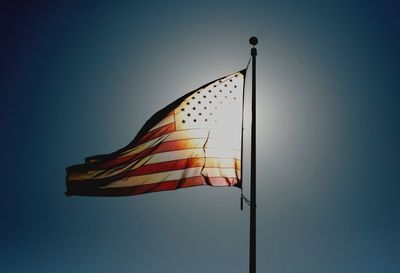 Low angle view of flag against blue sky