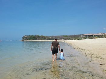 Rear view of woman standing on beach