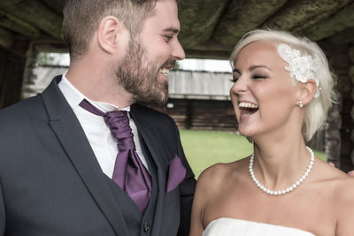 Happy bride and groom outside hut