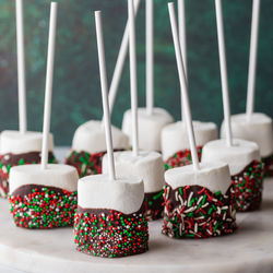 Sweet chocolate dipped marshmallow pops with festive sprinkles.