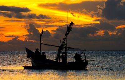 Silhouette boat in sea against sky during sunset