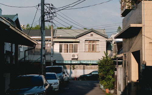 Road by buildings in city against sky