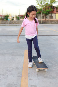 Full length of girl skateboarding on street