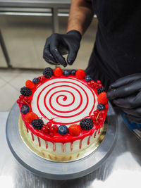 Midsection of man holding cake