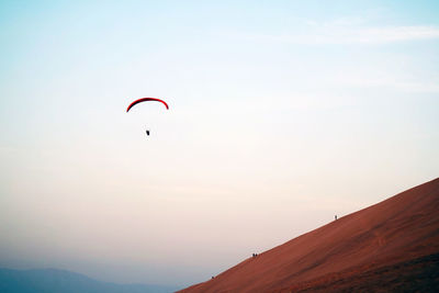 Low angle view of person paragliding against clear sky