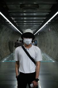 Portrait of young man standing in corridor