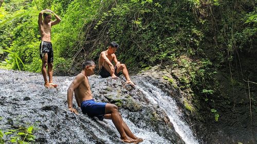 People on rock in forest