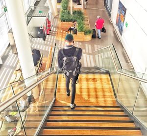 Rear view of people walking on staircase