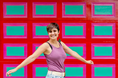 Young woman standing against wall