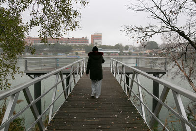 Women's walk on the footbridge of the guadalquivir river walking backwards