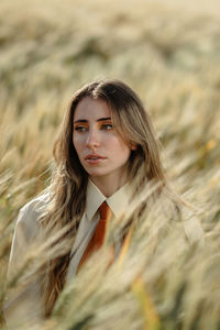 Portrait of young woman standing on field