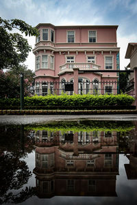 Building by lake against sky