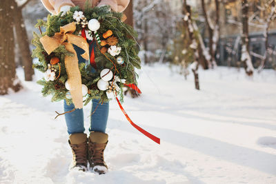 Woman holding snow covered field